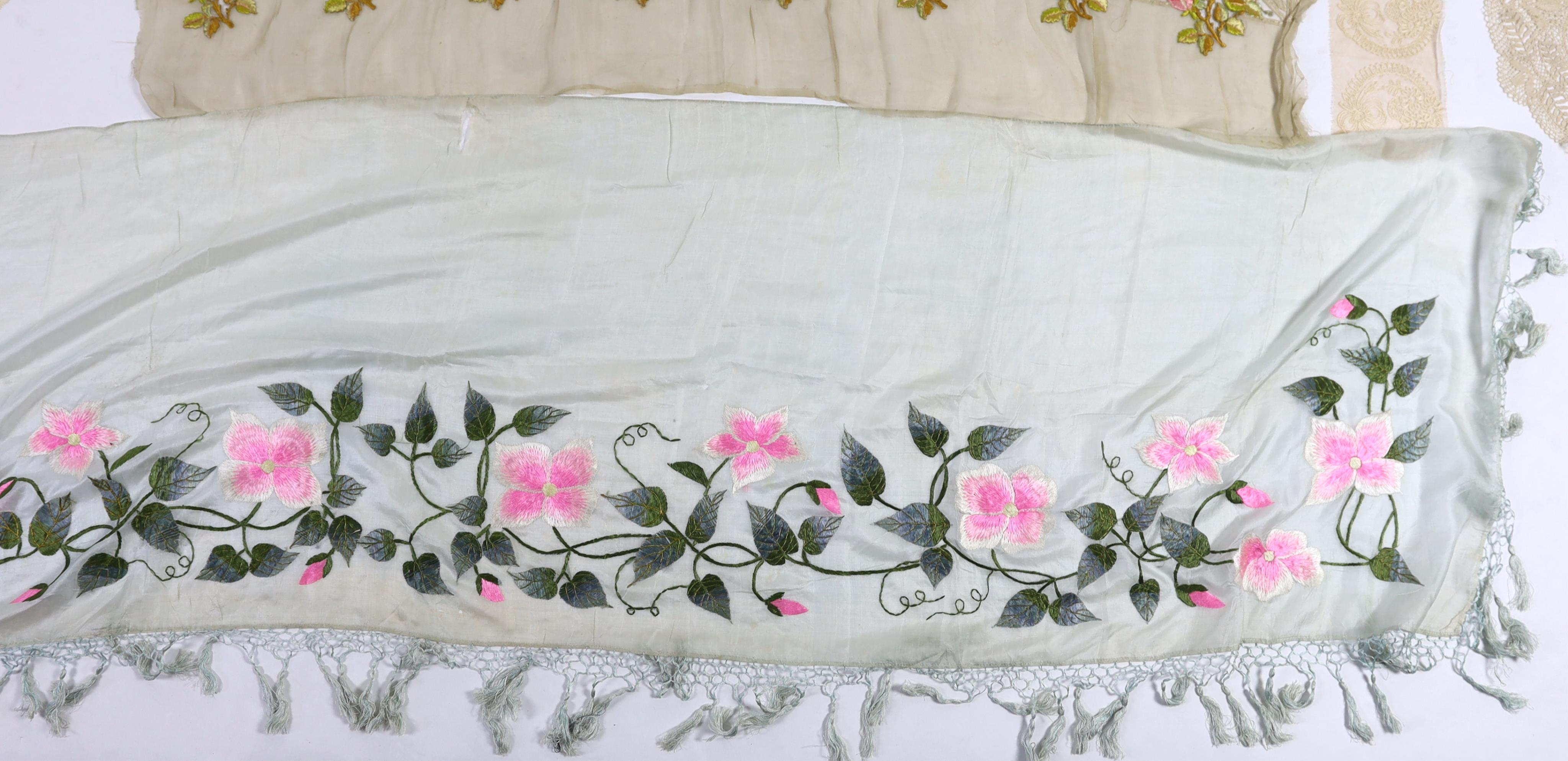 An early 20th century fine spun silk embroidered and fringed pelmet, a lace and polychrome embroidered border, possibly a panel to a dress, a needle run lace stole, a Normandy lace border to a circular mat, a bobbin lace